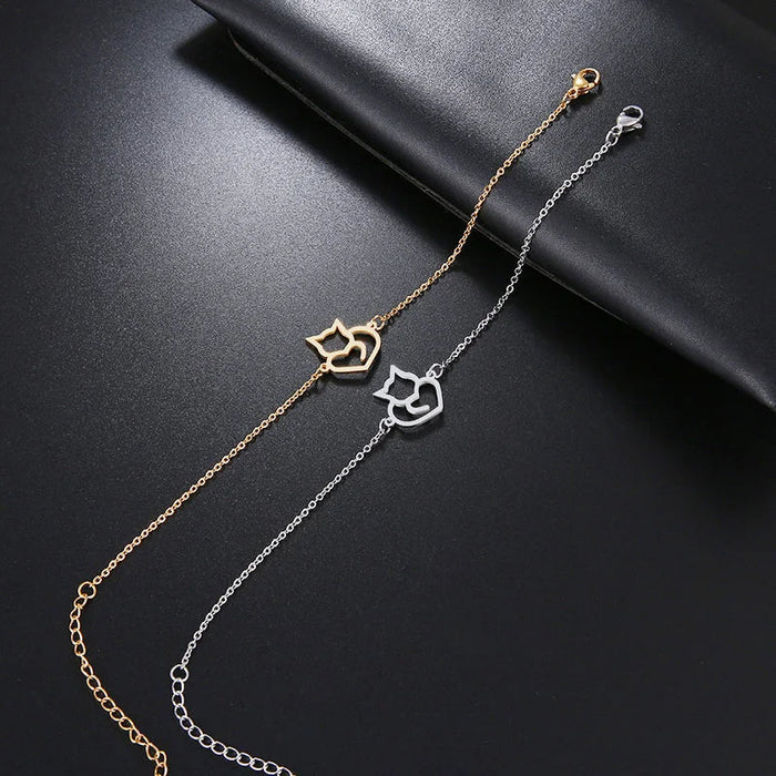 Cat and heart bracelet shown in gold and silver tone side by side