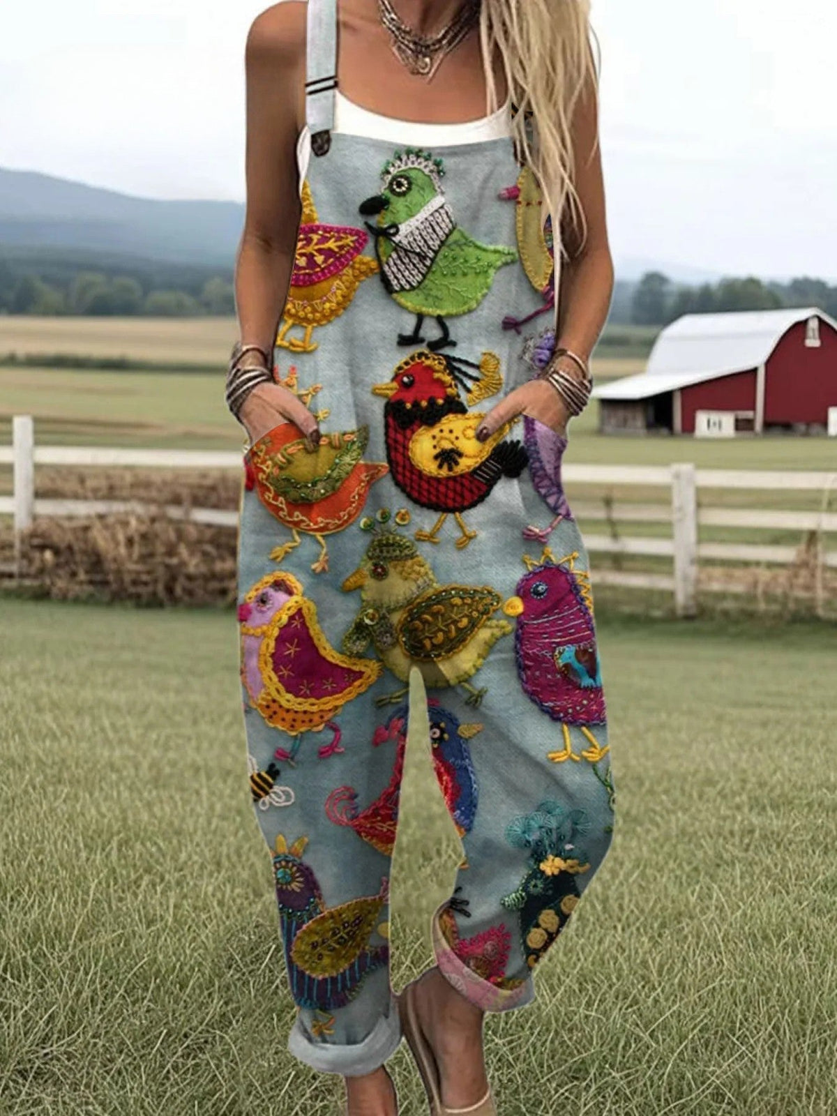 Vintage colourful bird print dungarees in pale blue, full-length front view with turned-up cuffs