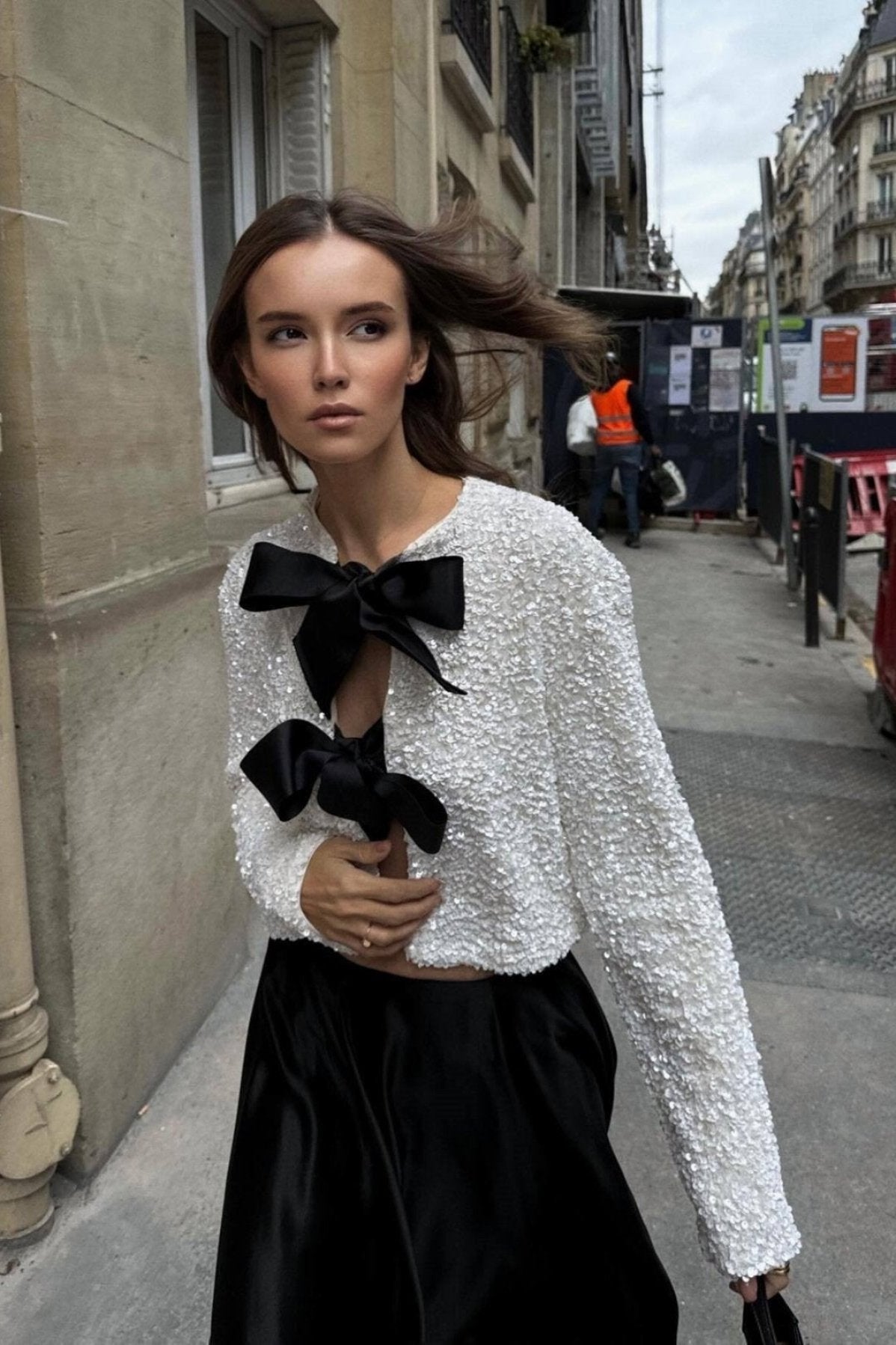 Anwen sequin blouse in cream with black front bows, worn with black skirt