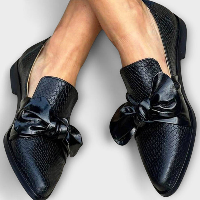 Claudia knot-detail loafers in black, worn front view with pointed toes