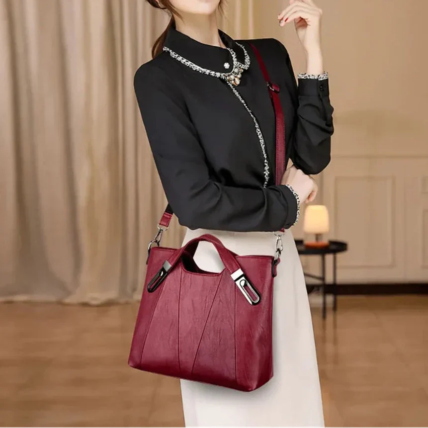 Woman carrying the Sienna handbag in burgundy across the body