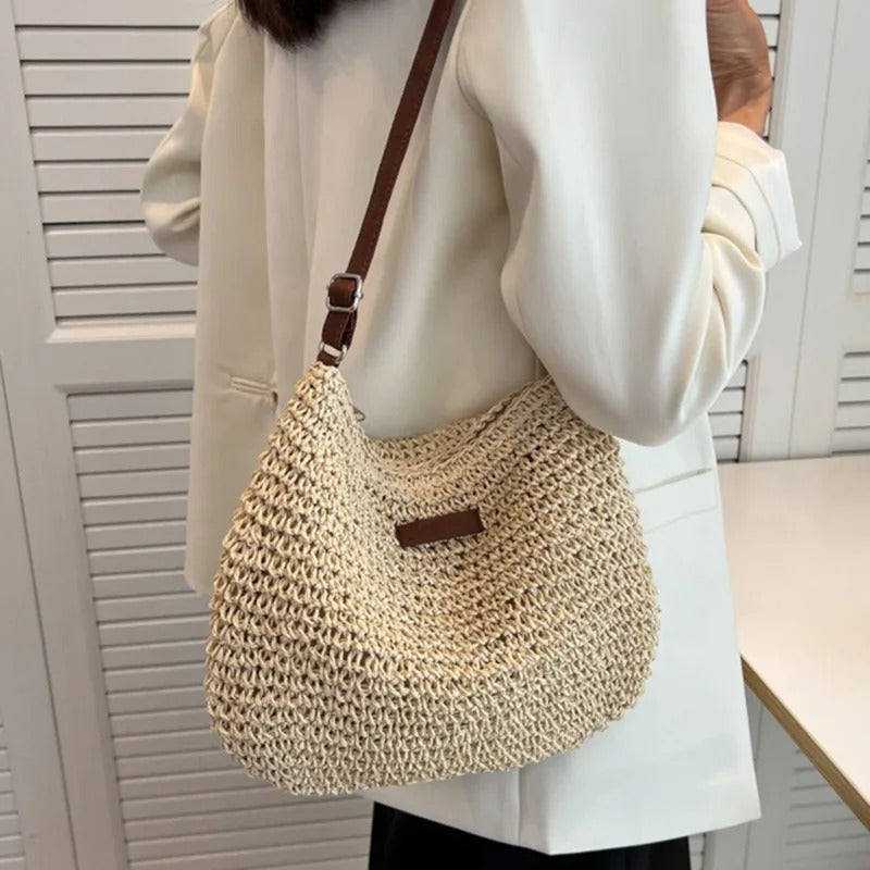 Woven shoulder bag in beige worn crossbody with a white blazer