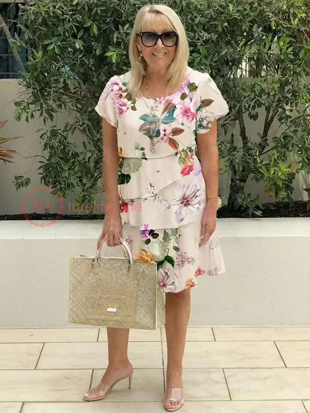 Giselle tiered ruffled dress in beige floral print styled with heels and tote