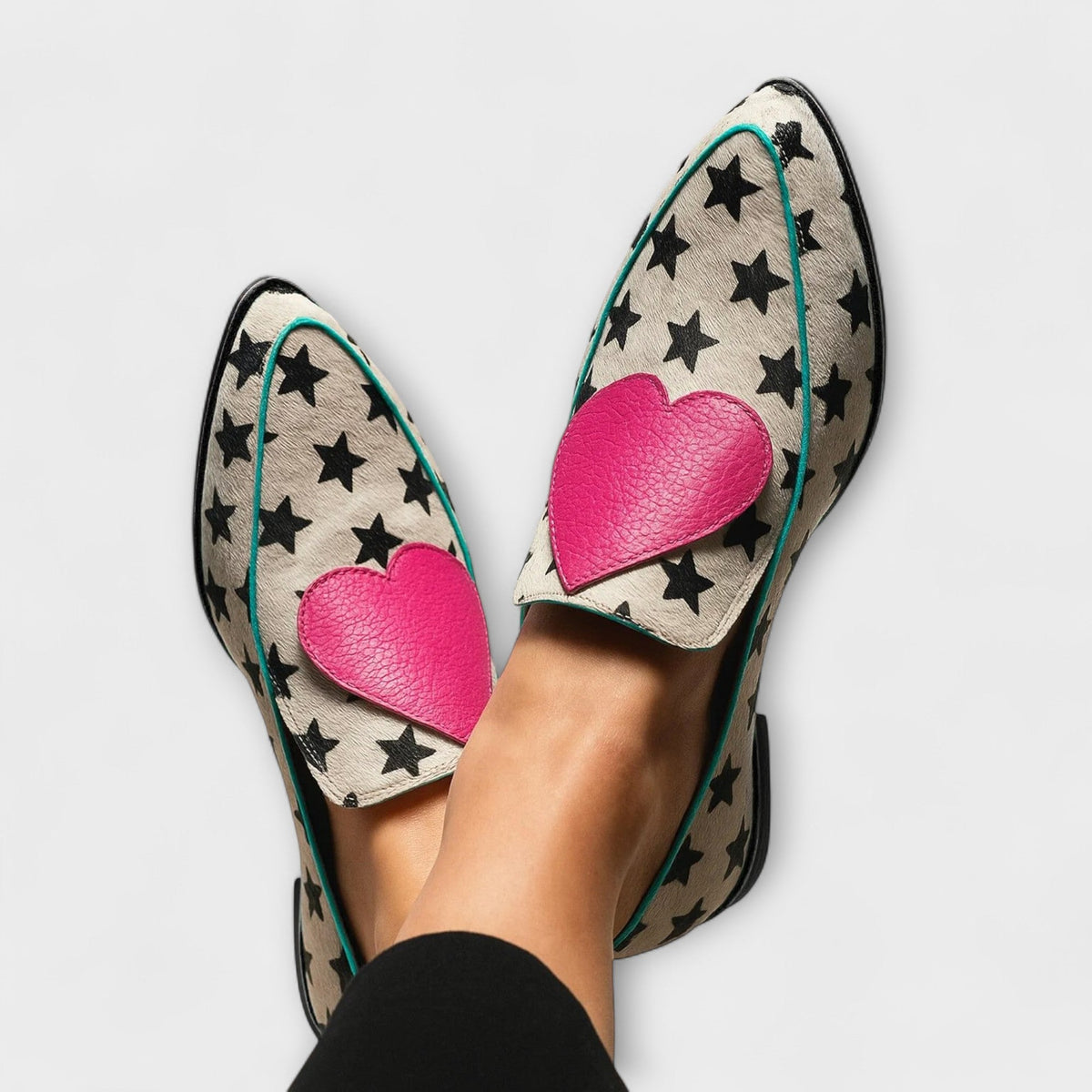 Helena loafers in beige with black star print and pink heart, worn close-up view