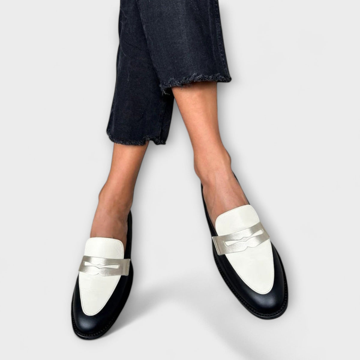 Iris black loafers with ivory vamp, side-on walking view