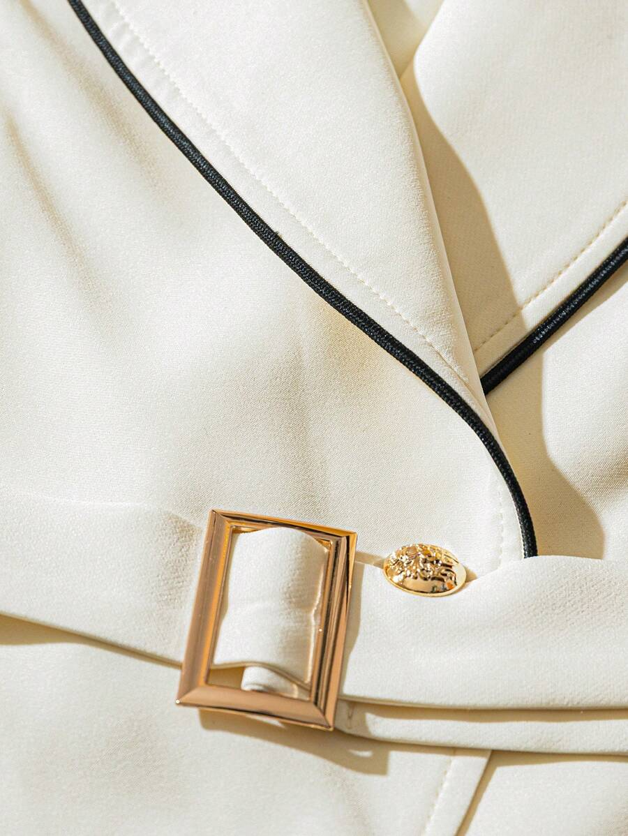 Sofja vest detail: gold square buckle, gold button and black lapel piping