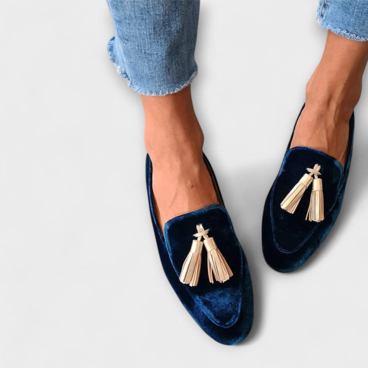 Celeste vintage-inspired loafers in navy with gold tassels, worn with jeans