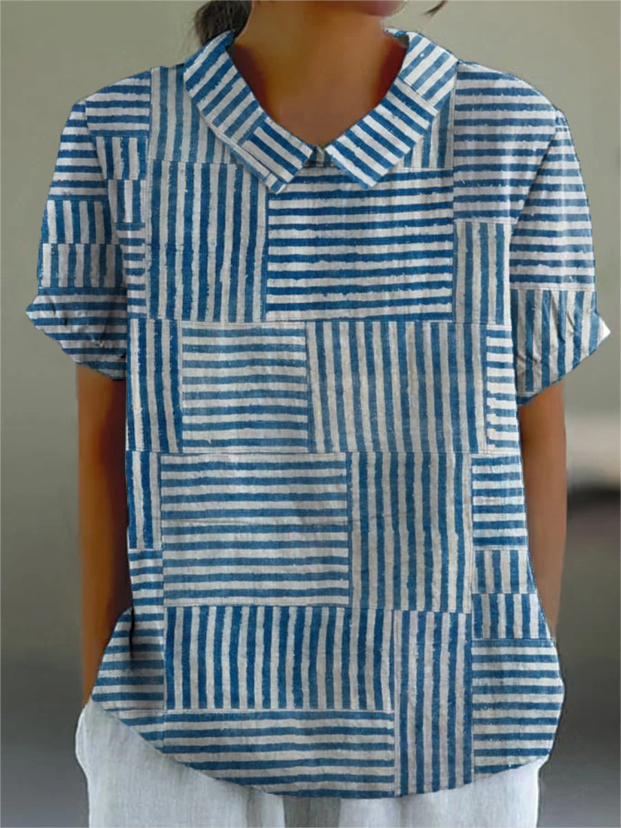 Amelia striped patchwork blouse in blue and white, front view worn with white trousers