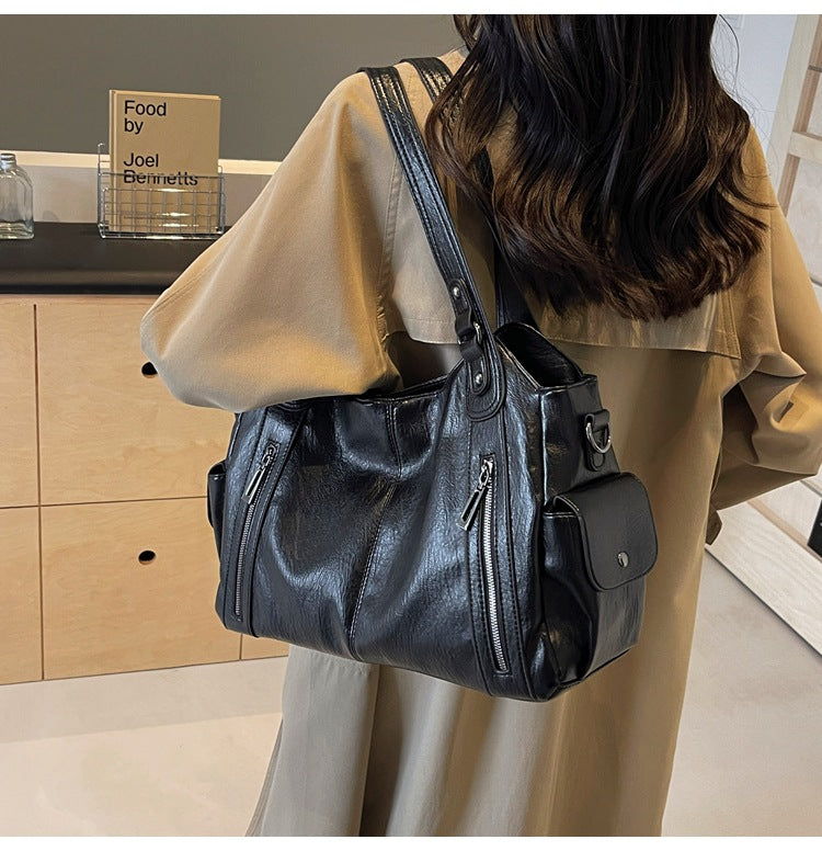 Rae handbag in black, close view of side pocket and zip detail