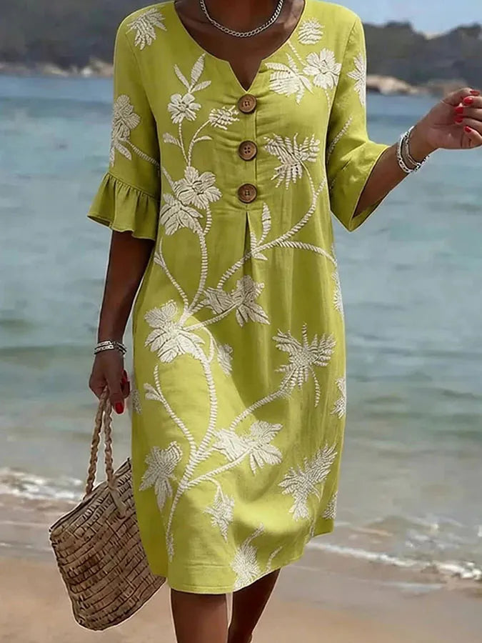 Yellow floral print casual dress with buttoned V-neckline, full-length front view on the beach