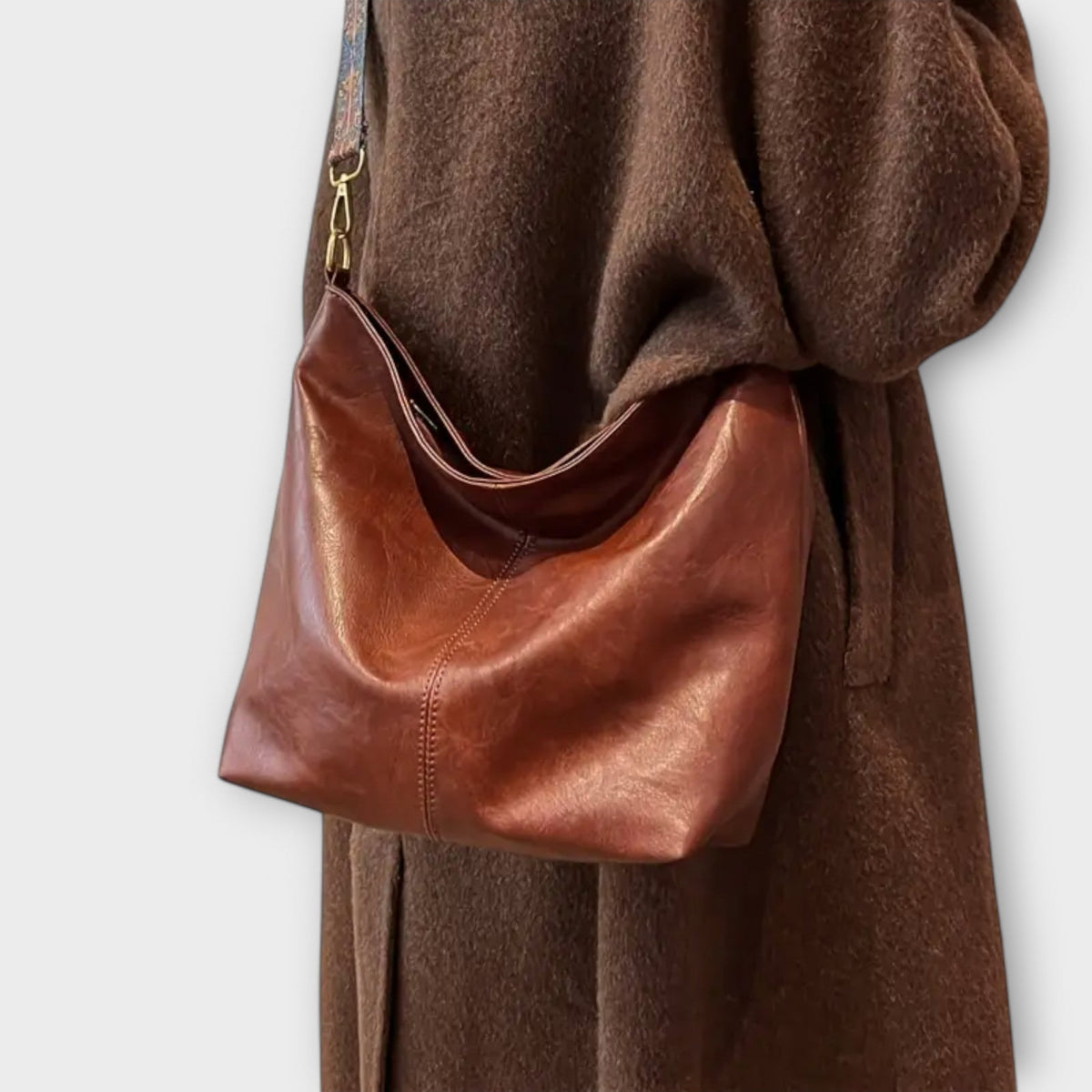 Agatha vintage shoulder bag in brown worn crossbody over a coat