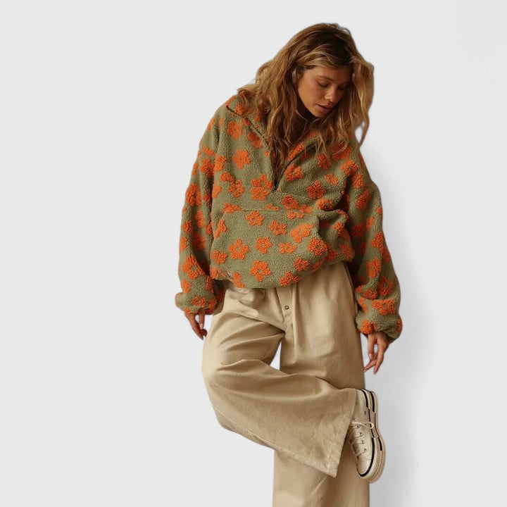Delysanne sweater in khaki with orange flowers, styled with wide beige trousers