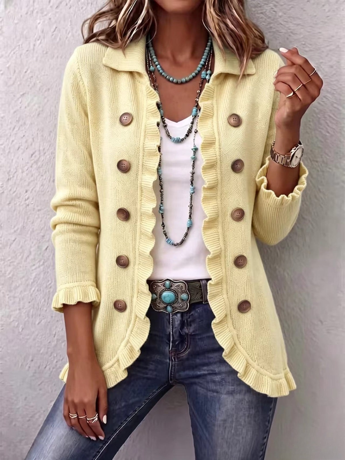 Liliana cream knit jacket with ruffle trims and brown buttons, worn open over jeans