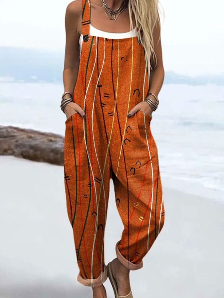 Artistic Line dungarees in orange with line print, full-length front view on the beach