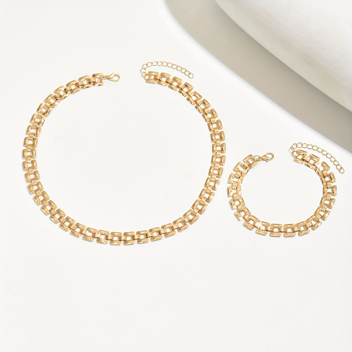 Gold necklace and bracelet set laid out showing extender chains