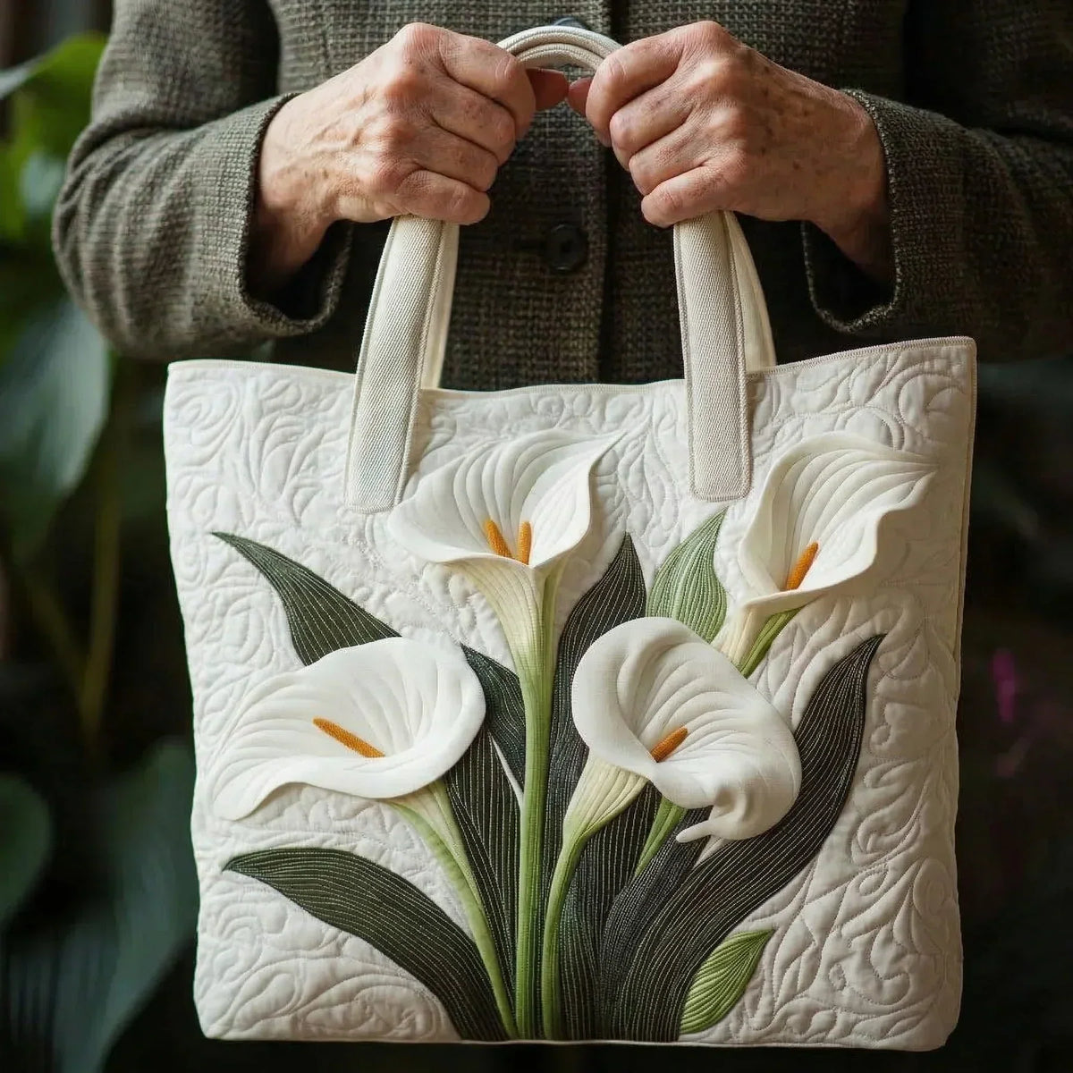 Cream arum lily tote bag held by both handles, close-up front view