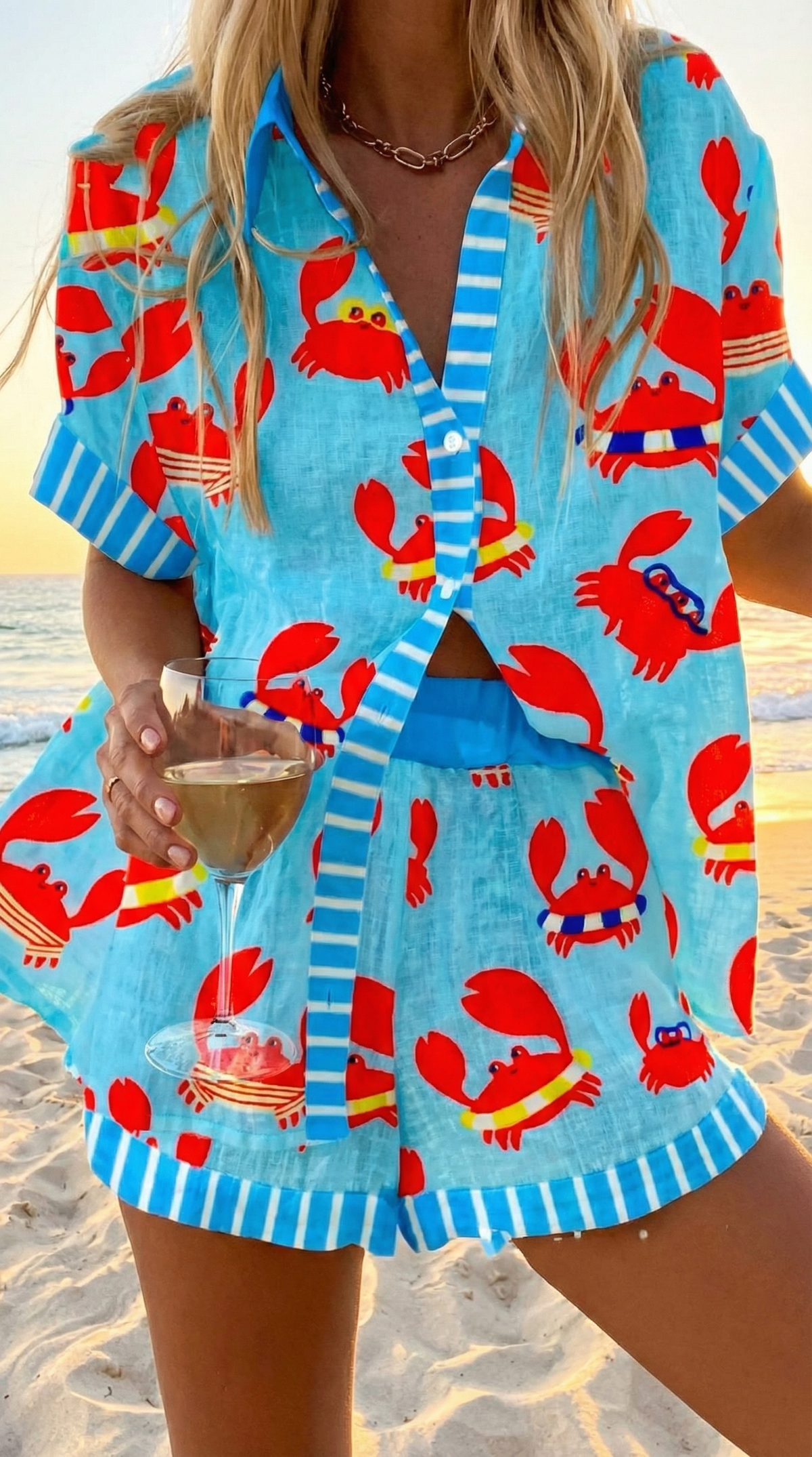 Marina summer co-ord set in blue with red crab print, worn on the beach