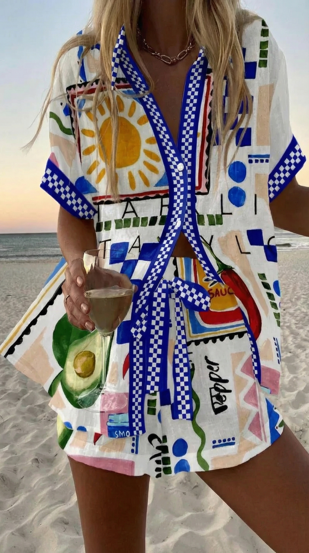 Fiesta summer co-ord set in white with blue checkerboard trim, worn on the beach
