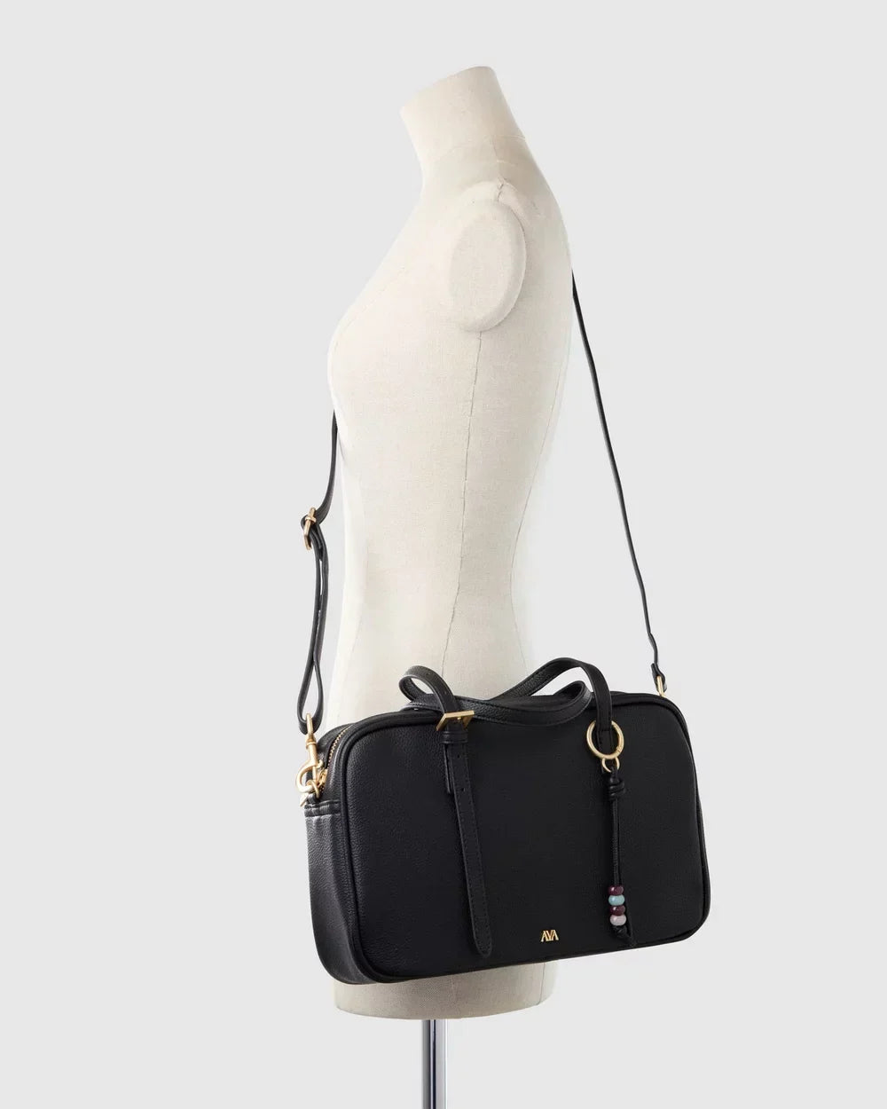 Lumière Paris bowler bag in black shown on a mannequin, crossbody view
