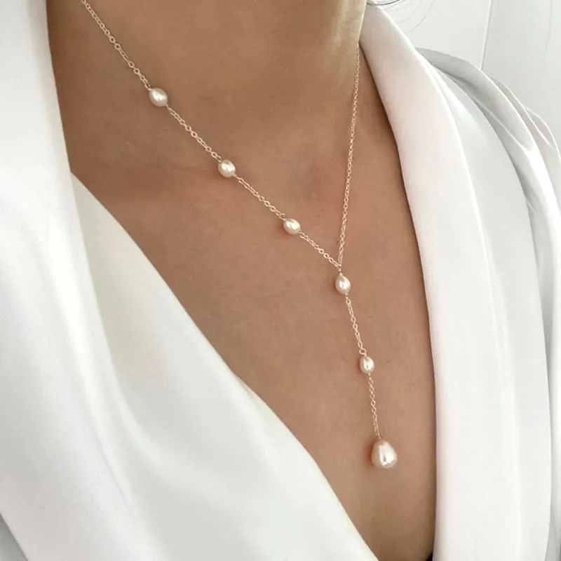 Pendant and pearl necklace in gold tone with teardrop pearl drop, worn close-up view
