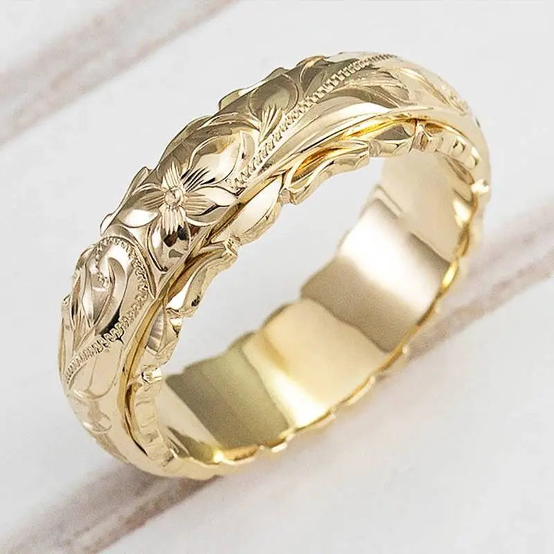 Mila gold ring with antique-inspired engraved flowers, close-up angled view