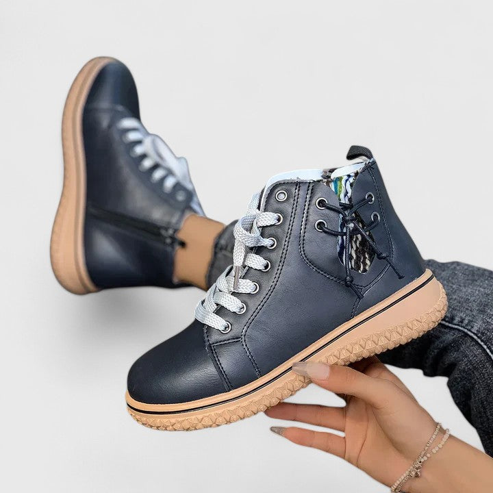 Brilly ankle boot in black held in hand, showing textured sole