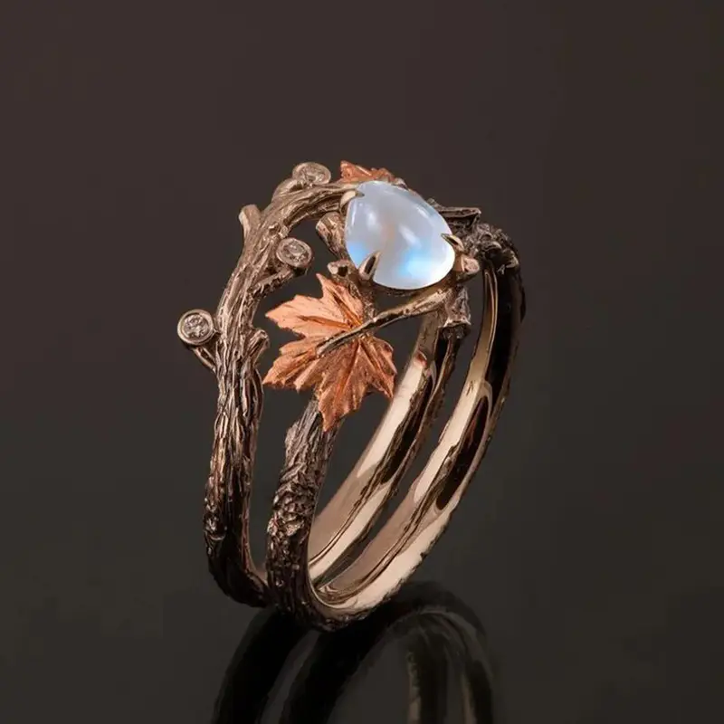 Moonstone ring with rose gold maple leaf and branch bands, side view