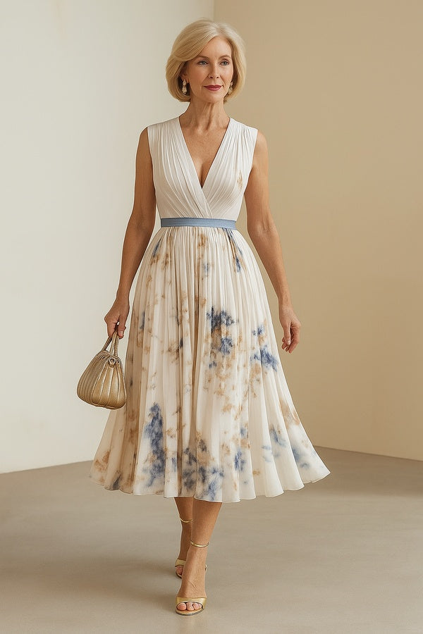 Paz floral pleated dress in cream and blue, sleeveless walking view