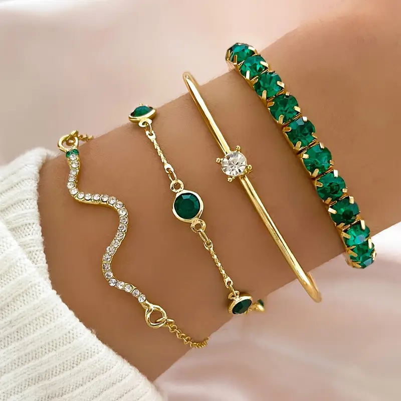 Vintage green zirconia bracelet set in gold, four bracelets stacked on the wrist