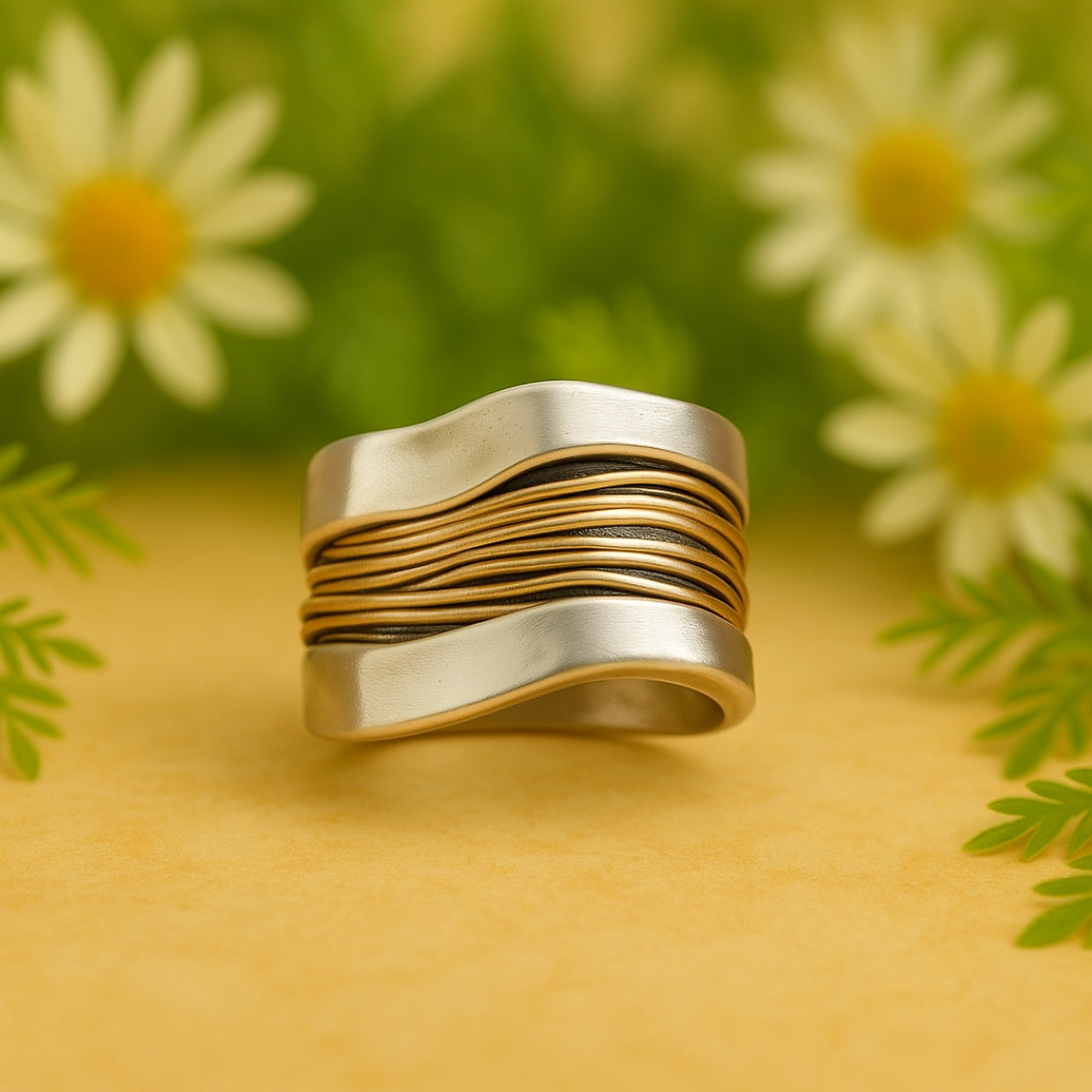 Two-tone ring with golden threads across a waved silver band