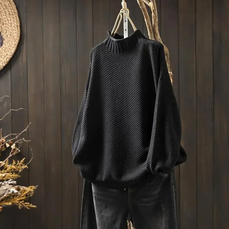 Aelyra chunky knit sweater in black, front view on hanger