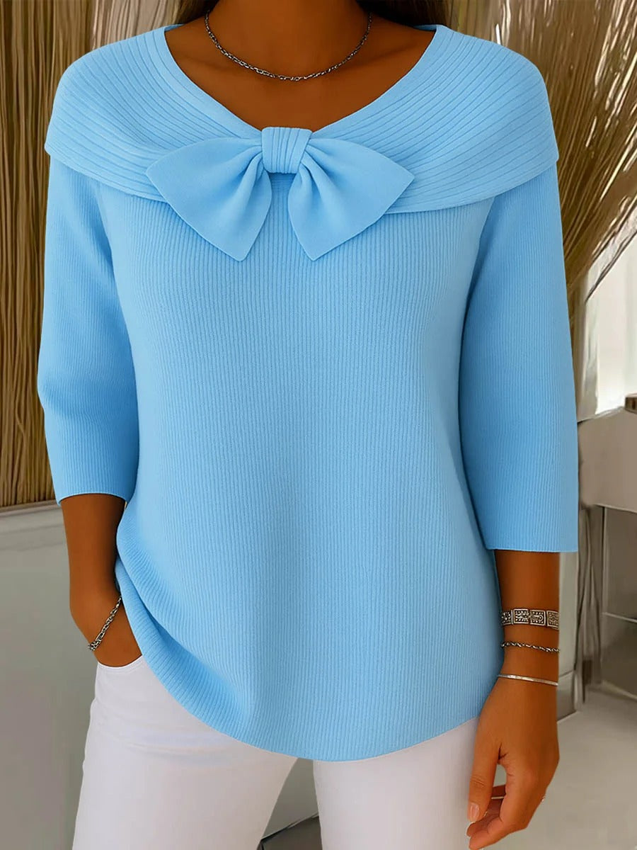 Tivella bow neckline sweater in light blue, front view worn with white trousers