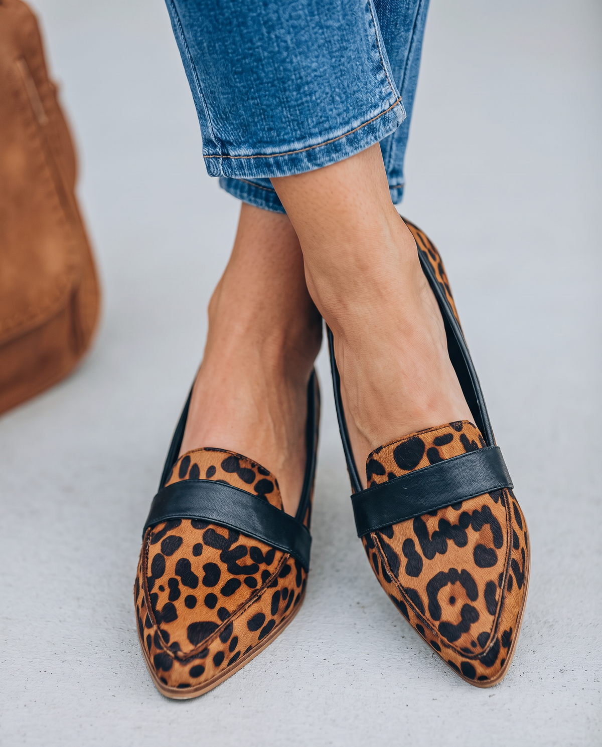 Pointed toe loafers in leopard print with black vamp band, worn with jeans