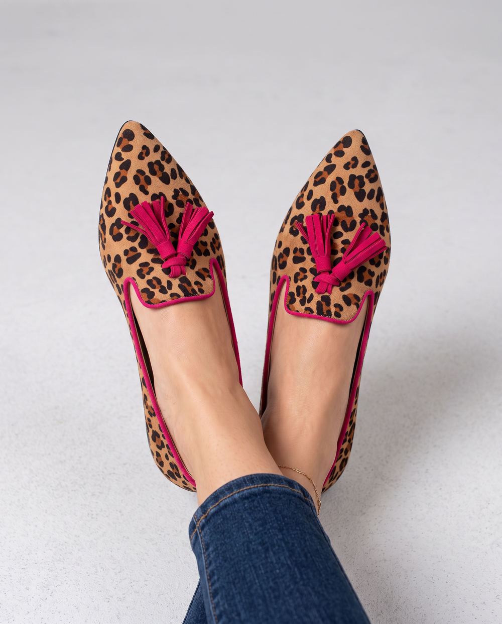 Ginevra suede leopard loafers with fuchsia tassels, overhead view on feet