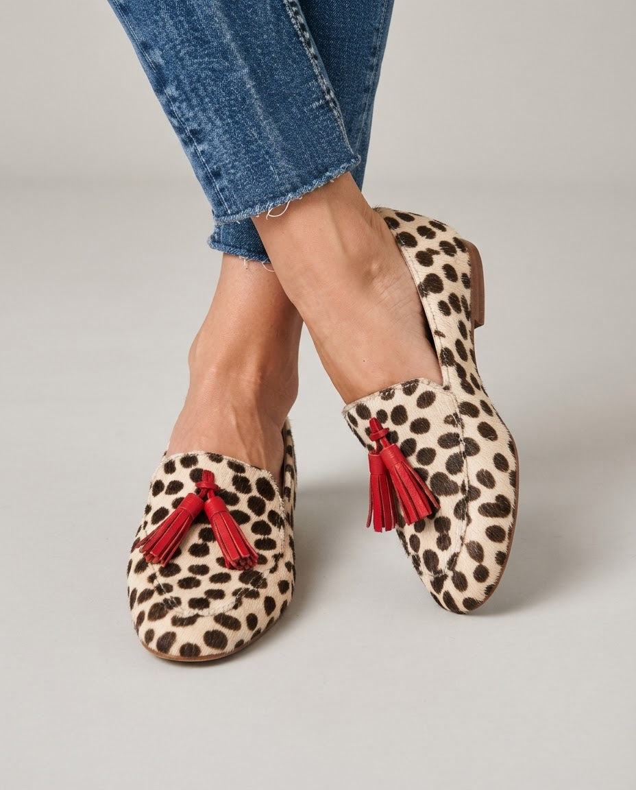 Aurora cream polka dot loafers with red tassels, worn with cropped jeans