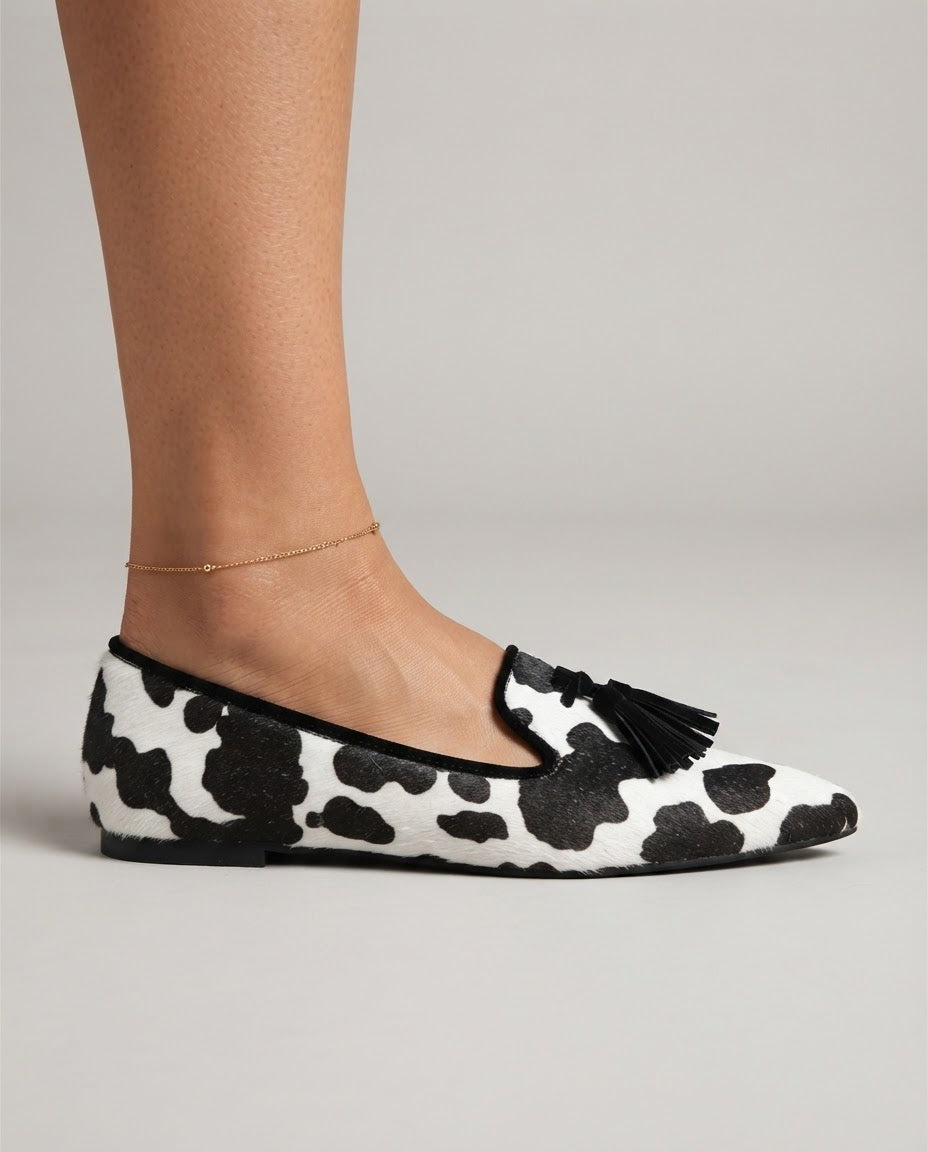 Ginevra cow print loafers in black and white, side view on foot