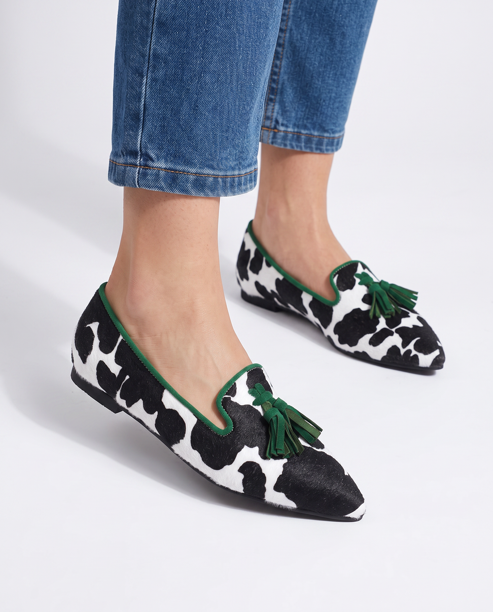 Ginevra cow print loafers with green tassels, worn with cropped jeans