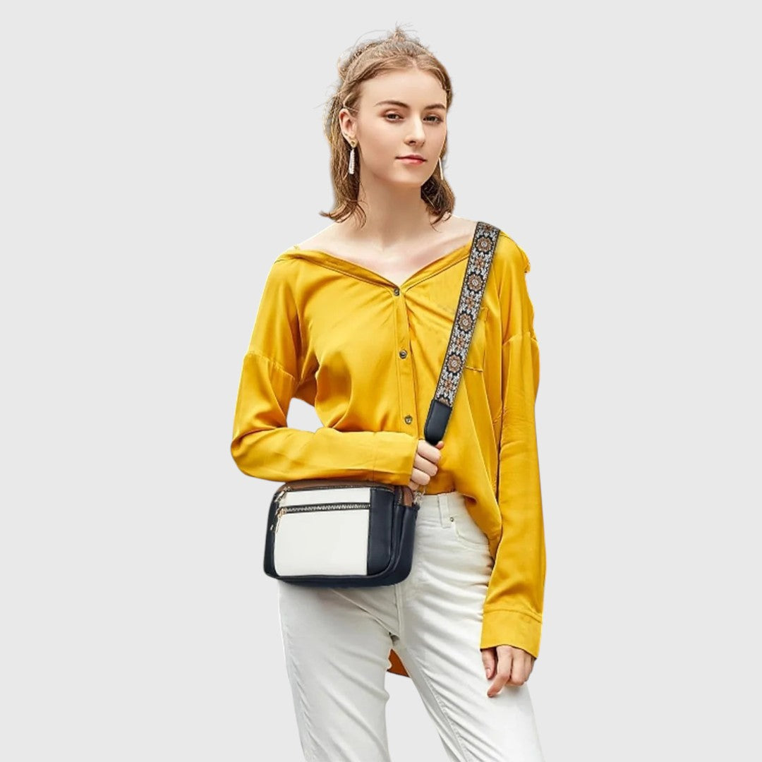 Dina shoulder bag in navy and white worn crossbody with a yellow shirt