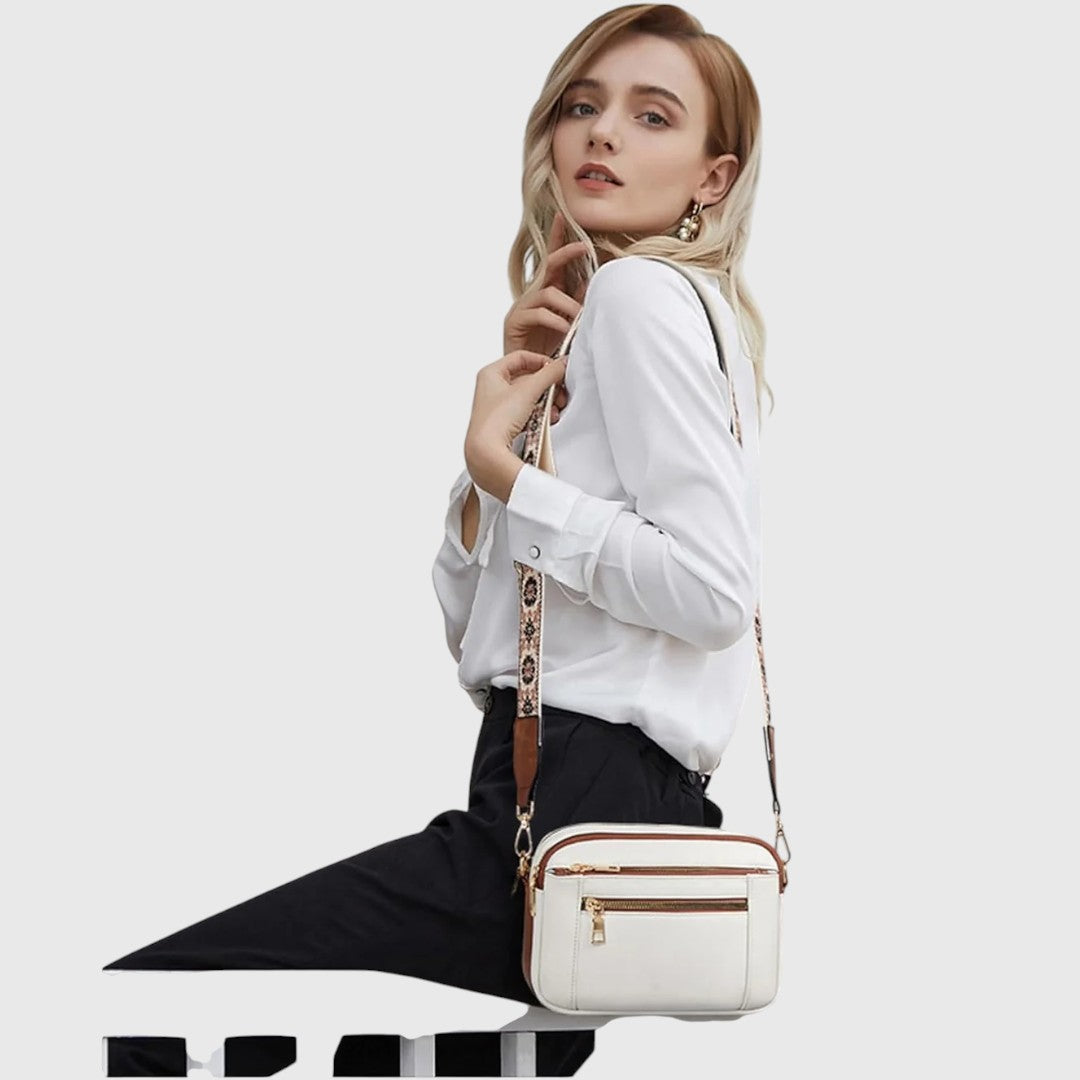 Dina shoulder bag in white with brown trim worn crossbody by a model