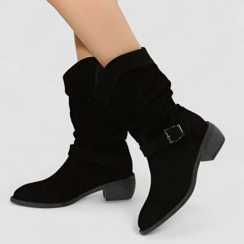 Elyse slouch-style western boots in black, worn side view with buckle strap