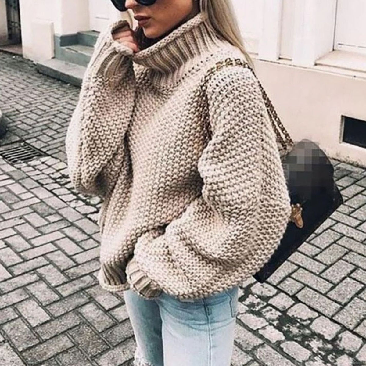 Oversized chunky knit turtleneck sweater in beige, worn with jeans, front view
