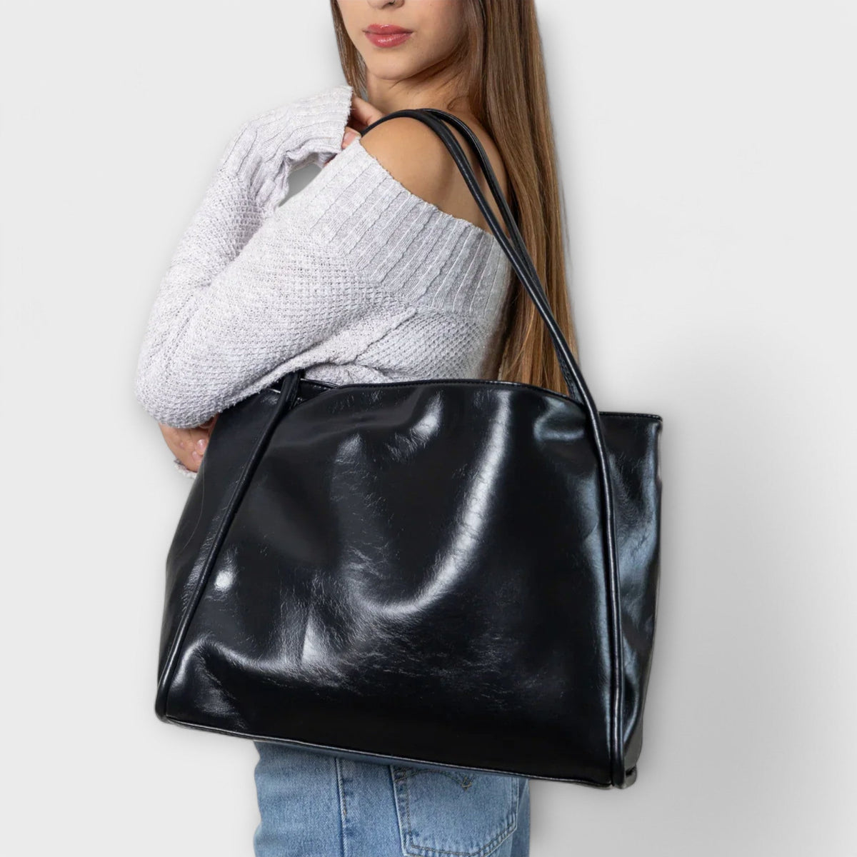 Valerie Blair tote bag in black carried on the shoulder with jeans and a knit